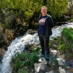 Nick poses in front of a waterfall during one of our day Hiking adventures